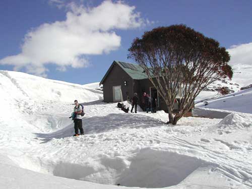 Illawong lodge in the snow on a sunny day, with a group of skiers